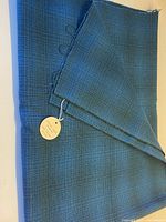 Folded blue check wool fabric with tag visible
