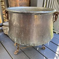 Overall view of cauldron on stand showing size and patina