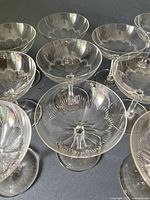 Group of champagne coupes showing etched floral design and hexagonal stems