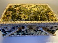 Overall view of wicker sewing basket with floral velvet lid and handles
