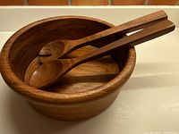 teak salad bowl with wooden spoon and fork inside view