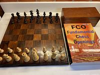 Board, pieces set up, book beside