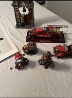 Overview of figurines, die cast trucks, and building replica from above on white sheet