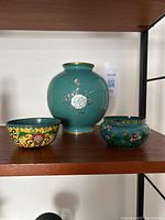 Front view of all three items together on a wooden shelf showing size and design details