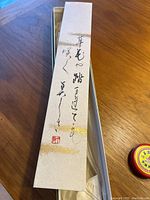 Vertical Japanese calligraphy scroll with a red seal stamp at bottom