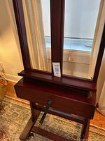 Front view of easel showing walnut finish and crank handle.