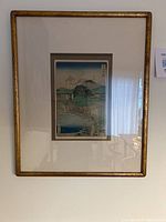 Full view of the framed Japanese print showing matting and gold frame.