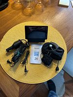 Photo of Sirius portable satellite radio receiver with power adapters and Plantronics Bluetooth headset on woven placemat.