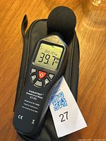 Photo showing the full front of the Kasuntest KT-202 sound level meter resting on its carrying case, displaying a sound level reading of 39.7 dBA.
