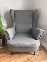 Front view of gray wingback chair showing tufted back and seat cushion