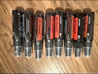 Front view of eight unopened DoTerra On Guard spray bottles arranged on a wooden surface.