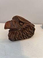 Front angle showing detailed carved feathers, eyes, and beak of the eagle head sculpture