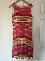 Full view of sleeveless striped dress in pink, orange, white, and brown with cut-out waist detail