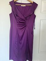 Purple sleeveless dress with wide collar and gathered detail on hanger