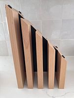 Side view showing the five angled slots of the wooden magnetic knife block with varying heights and natural wood grain finish.