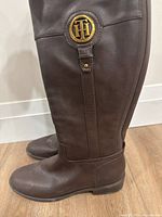 Side view of the brown leather boot showing the Tommy Hilfiger gold emblem.