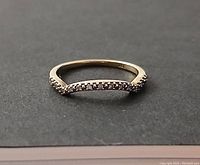 Front view of 10K gold ring with tiny diamonds on curved top band