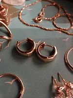 Pair of earrings on teal background with other jewelry present