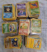 Multiple stacks of assorted Pokémon cards laid out showing fronts including Staryu, Hitmonlee, Charmander, Bulbasaur, Zubat