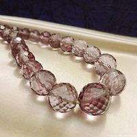 Close-up of larger faceted round amethyst beads showing cut and color