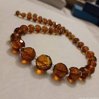 Close angle photo highlighting the faceted amber topaz beads and crystal spacers of the necklace.