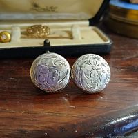 Front view of antique sterling silver earrings with engraved pattern