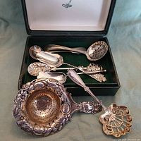 All seven pieces laid out in velvet-lined box with lids open plus on cloth