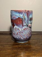 Porcelain vase showing front curved side with colorful glaze and sgraffito decoration