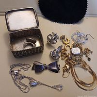 Full assortment of jewelry items along with small metal box shown from overhead view.