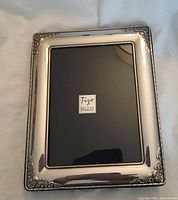 Front view of silver picture frame with Tizo sterling mark on display card inside.