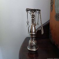 Front angle view of the vintage sterling Egyptian pipe ornament showing its detailed body and hanging charms.