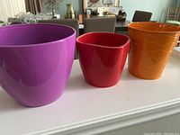 Photo showing all three pots: purple plastic, red ceramic, orange tin