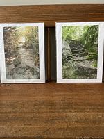 Two signed prints wrapped in plastic showing outdoor stone pathways with forest surroundings.