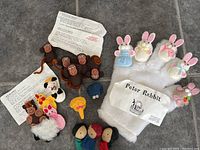 Full view of five sets of finger puppets including monkeys, rabbits, farm animals, and children characters along with printed story pages.