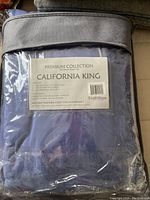 Packaged premium collection six-piece California King sheet set in blue color, labeled with dimensions and care instructions
