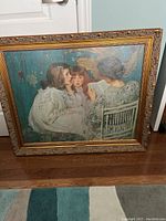 Full view of the framed reproduction oil painting showing three figures seated together under soft lighting, providing an overview of the artwork and frame condition.