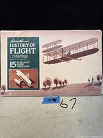 Box front view showing Eddie Bauer History of Flight 15 excellent paper airplanes, vintage illustration of early flight airplane and silhouette of Wright brothers.