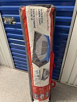 Close-up of tent carry bag showing Outbound 10-person cabin tent packaging with model info and branding.