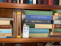 Books arranged on a wooden shelf showing various classic titles.