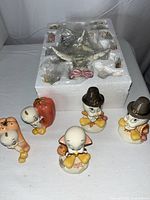 Photo showing five porcelain Tweety Bird figurines in Thanksgiving theme with pumpkins and pilgrim hats in front of styrofoam storage containing the tree and more ornaments.