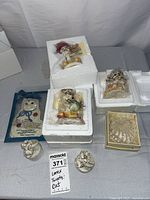 Overview photo of the Lenox figurines including Tweety Bird in foam packaging, glass heart dish, and several small cat figurines.