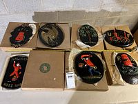All eight metal plaques arranged on cardboard boxes with visible fire-themed embossed or cast designs.