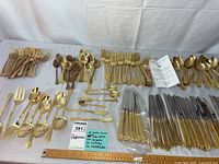 Overview of the entire silverware lot showing multiple forks, spoons, knives, butter knives, and salad forks.