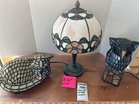 Three lamps displayed together: table lamp with floral shade, cat and owl mosaic accent lamps.