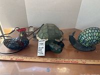 All three lamps side by side on wood surface with ruler: snail, turtle, chicken