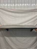 Front view of the stainless steel wall shelf showing full length and flat surface