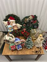Full view of the Christmas lot showing wreaths, various figurines, and ornaments placed on a wooden table