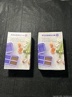 Two boxed Food Blox food storage units from the Periwinkle Collection shown on a dark surface.