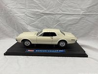 Side view of white 1967 Mercury Cougar XR7 model car on black display base showing detailed body design and wheels.