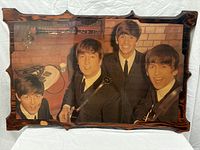 Full view of the laminated wood print showing The Beatles in suits holding instruments.